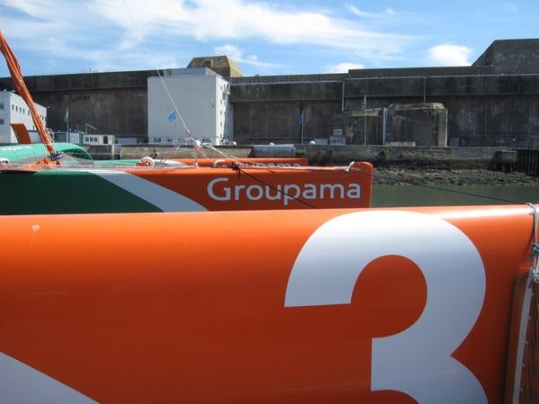 Groupama3, háttérben egy tengeralattjáró-bázis